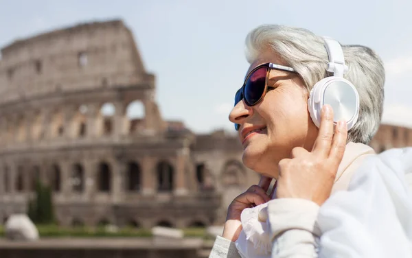 Vecchia donna in cuffia ascolta musica a roma — Foto Stock