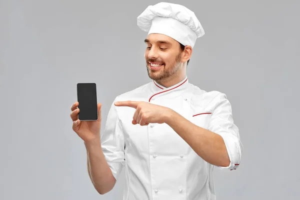 Щасливий усміхнений чоловічий шеф-кухар, що показує смартфон — стокове фото