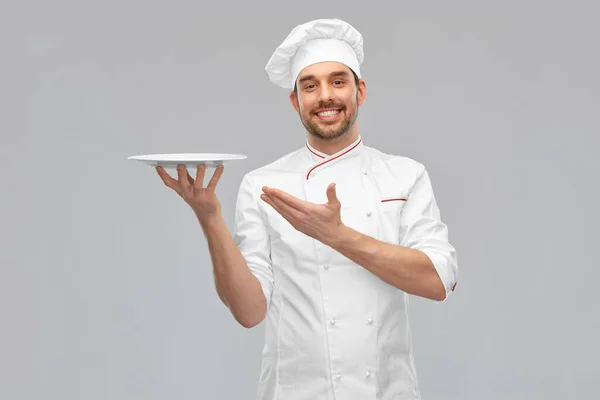 Feliz sorrindo chef masculino segurando prato vazio — Fotografia de Stock