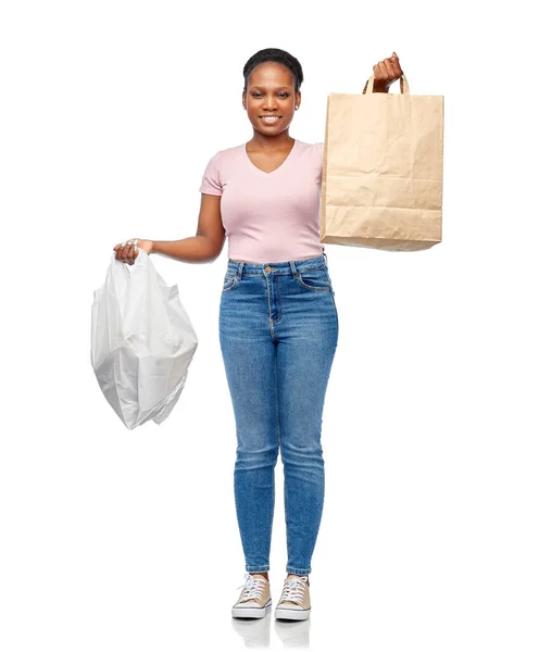 Mujer africana que compara bolsas de papel y plástico — Foto de Stock