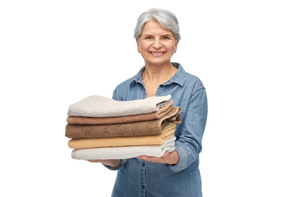 Mujer mayor sonriente con toallas de baño limpias —  Fotos de Stock