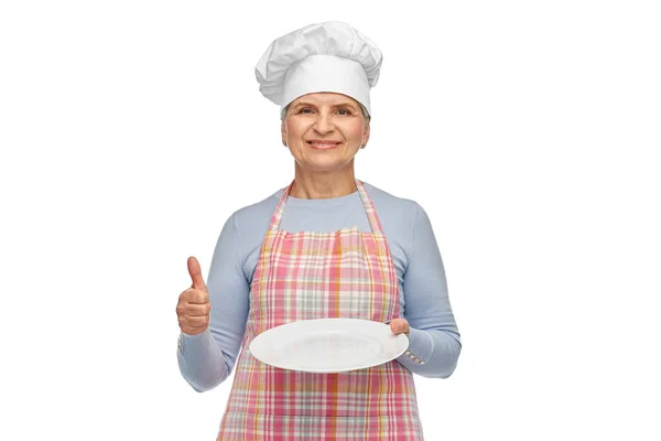 Sorrindo mulher sênior ou chef segurando prato vazio — Fotografia de Stock