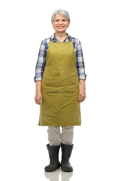 Portrait of smiling senior woman in garden apron — Stock Photo, Image