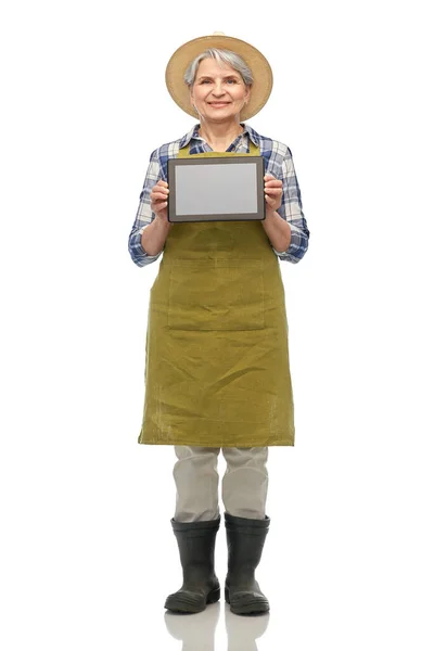 Happy senior woman in garden apron with tablet pc — Stock Photo, Image