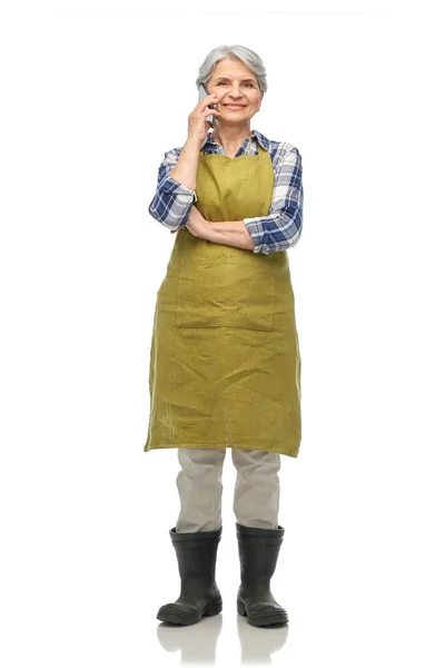 Senior woman in garden apron calling on smartphone — Stock Photo, Image