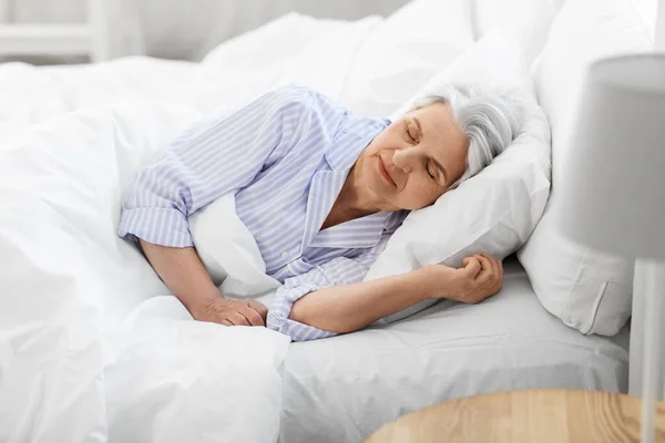 Mulher sênior dormindo na cama em casa quarto — Fotografia de Stock