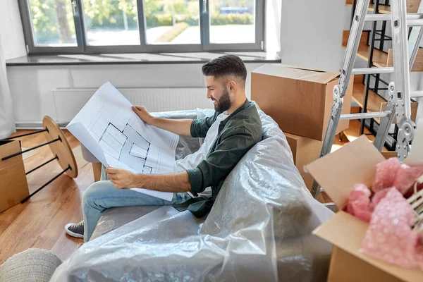 Homem feliz com o blueprint que se move para a casa nova — Fotografia de Stock