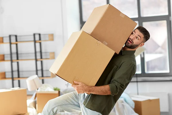 Adam ağır kutular taşıyor ve yeni evine taşınıyor. — Stok fotoğraf