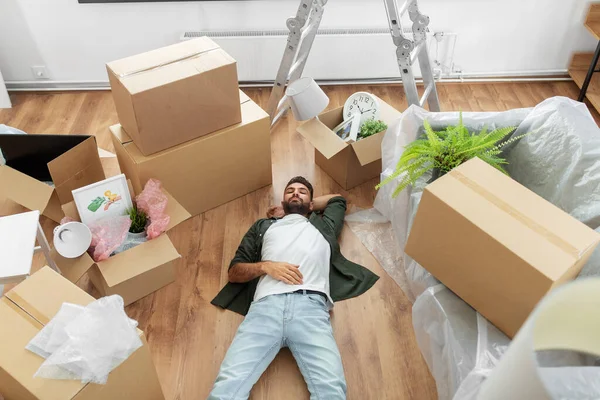 Человек с коробками переезжает в новый дом — стоковое фото