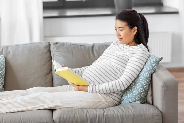 Feliz embarazada leyendo libro en casa — Foto de Stock