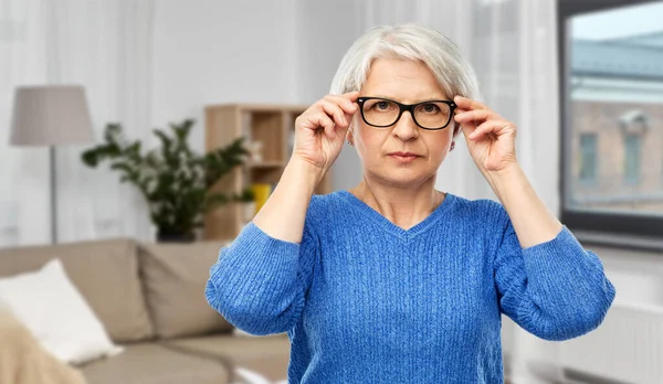 Portrait of senior woman in glasses over grey — Stock Photo, Image