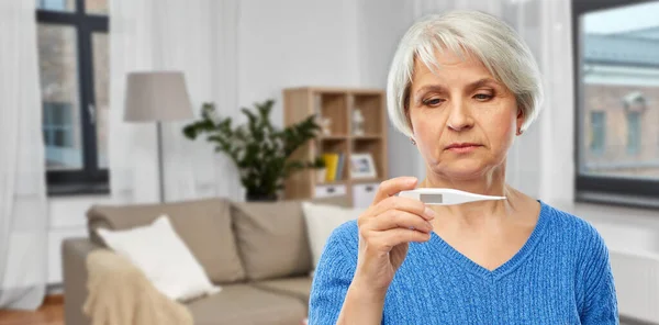 Sjuk äldre kvinna med termometer — Stockfoto