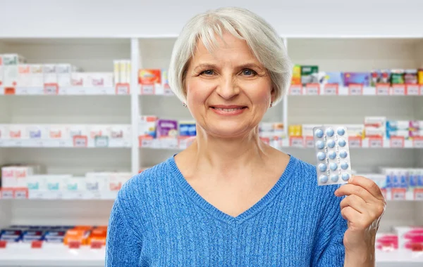 Mujer mayor sonriente con paquete de píldoras — Foto de Stock