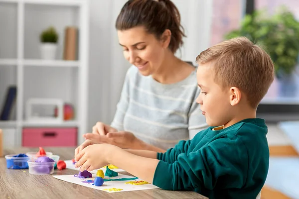 Madre e figlio giocare con la modellazione argilla a casa — Foto Stock