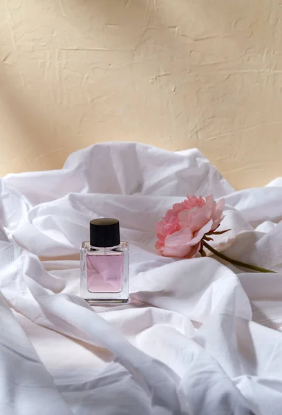 Bottle of perfume and flower on white sheet — Stock Photo, Image