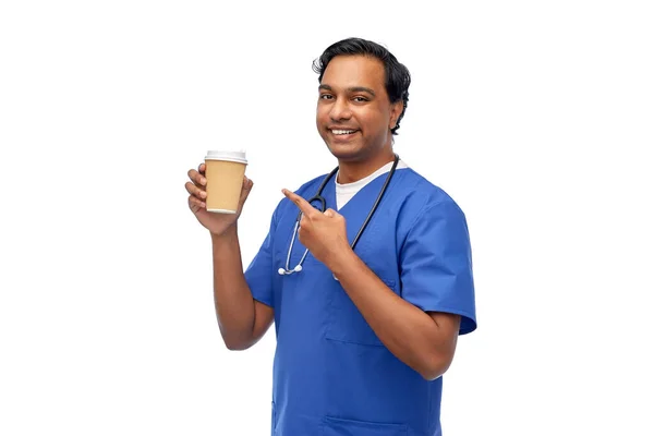 Médico varón con estetoscopio bebiendo café — Foto de Stock