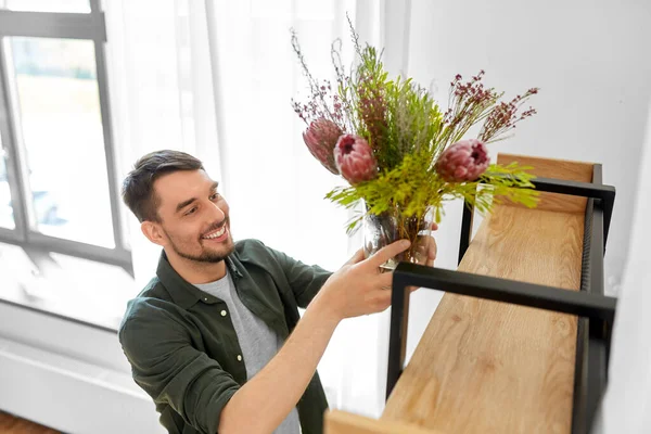 Homem decoração casa com flores em vaso — Fotografia de Stock