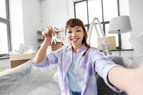 Mujer asiática con llaves tomando selfie en nuevo hogar —  Fotos de Stock