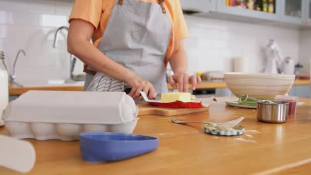 Ung kvinna med smör matlagning mat på kök — Stockvideo