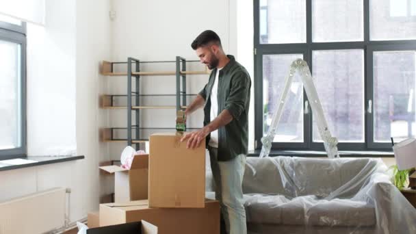 Mann mit Klebeband-Verpackungsbox zu Hause — Stockvideo