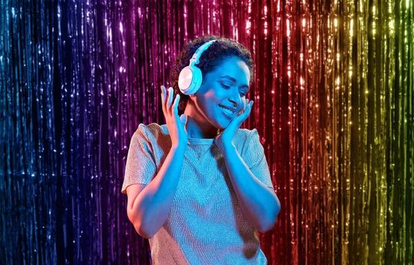 Mujer con auriculares escuchando música en la fiesta —  Fotos de Stock