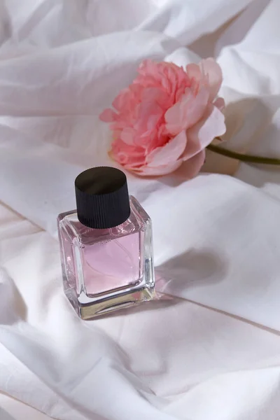 Bottle of perfume and flower on white sheet — Stock Photo, Image