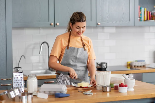 Šťastná mladá žena vaření jídlo na kuchyni doma — Stock fotografie