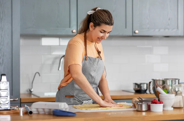 Kadın evde yemek pişiriyor ve yemek pişiriyor. — Stok fotoğraf