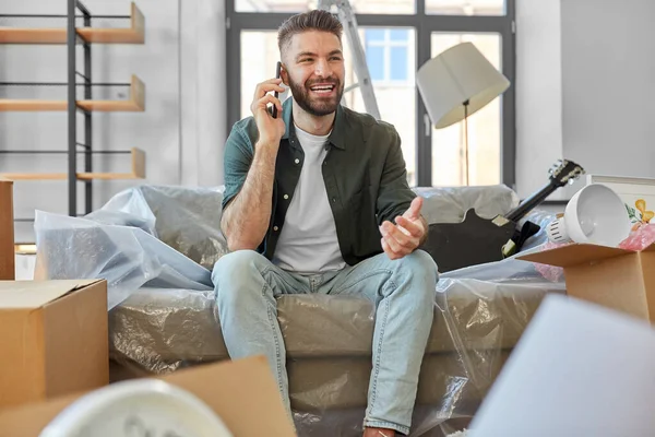 Hombre feliz llamando a un teléfono inteligente que se muda a un nuevo hogar —  Fotos de Stock
