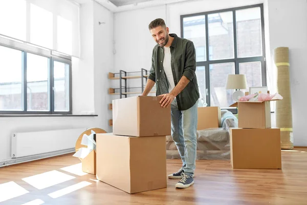 Hombre feliz con cajas mudándose a un nuevo hogar —  Fotos de Stock