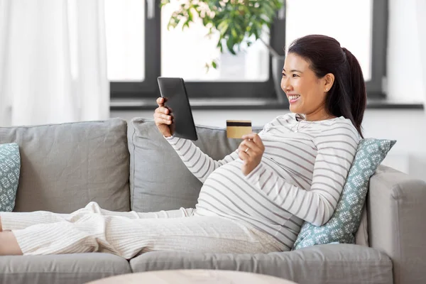 Femme enceinte avec tablette pc et carte de crédit — Photo