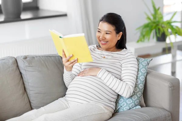 Szczęśliwy w ciąży kobieta czytanie książki w domu — Zdjęcie stockowe