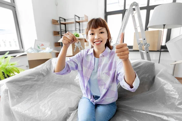 Asian woman with keys taking at new home — Stockfoto