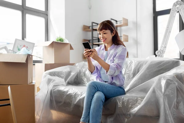 Asiatique femme avec smartphone déménagement dans nouvelle maison — Photo