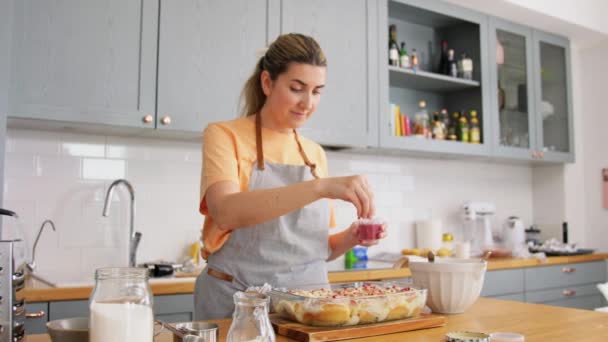 Mujer decoración bollos de rollo con frambuesas secas — Vídeos de Stock