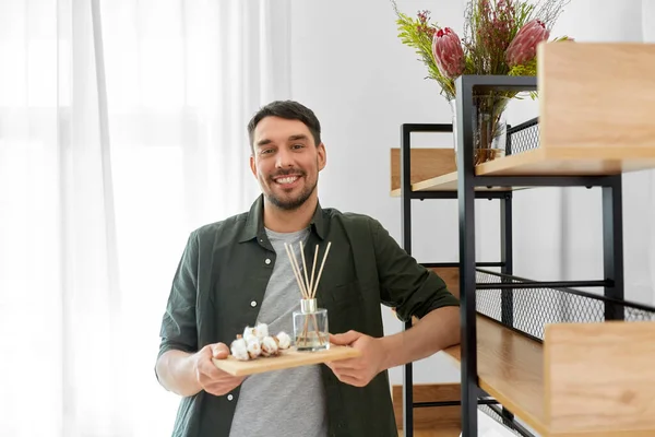 Man placing aroma reed diffuser to shelf home — Stock Photo, Image