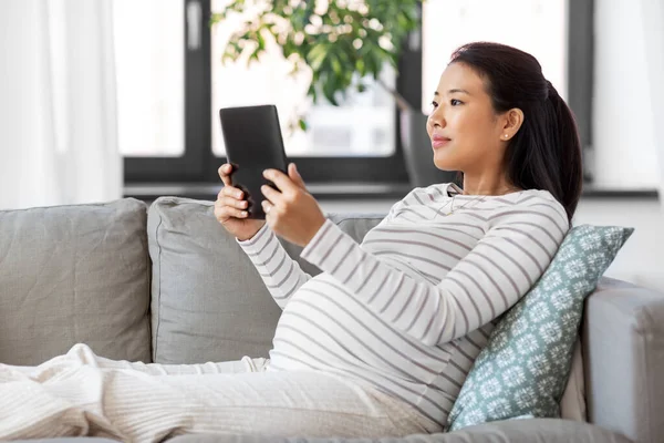 Feliz embarazada mujer asiática con tableta pc en casa — Foto de Stock