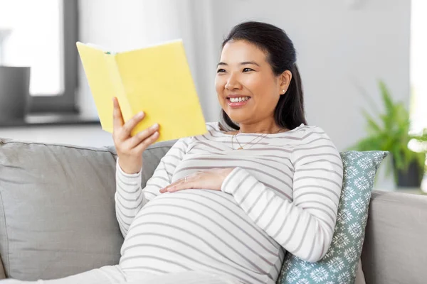 Heureuse femme enceinte lecture livre à la maison — Photo