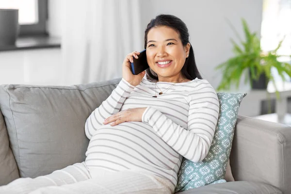 Mulher grávida feliz chamando no smartphone em casa — Fotografia de Stock