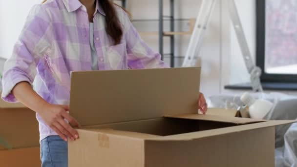 Wanita dengan kotak pengepakan pita perekat di rumah baru — Stok Video