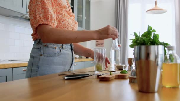 自宅のキッチンでモヒートカクテルを飲む女性 — ストック動画