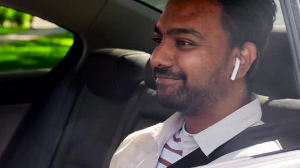 Passagerare med hörlurar och mobiltelefon i taxibil — Stockvideo