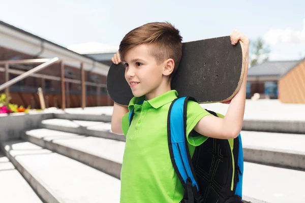 Счастливый студент с рюкзаком и скейтбордом — стоковое фото