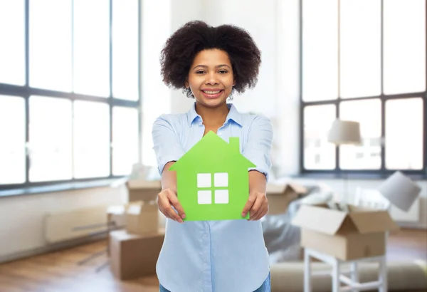 新しい家に緑の家のアイコンを持つアフリカの女性 — ストック写真