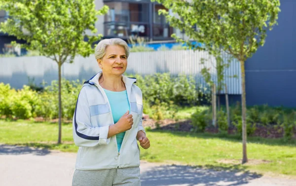 Sportowy senior kobieta działa wzdłuż w mieście — Zdjęcie stockowe