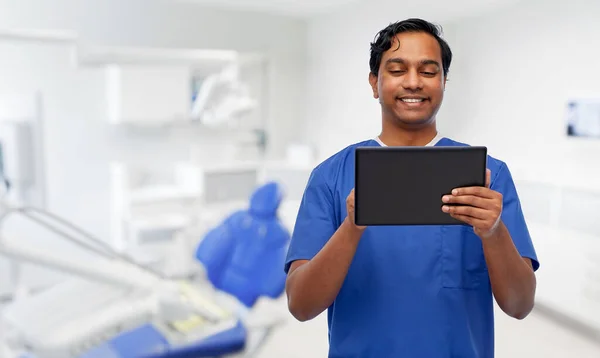 Lächelnder Arzt mit Tablet-PC in Zahnarztpraxis — Stockfoto