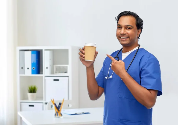 Męski lekarz ze stetoskopem pijący kawę — Zdjęcie stockowe