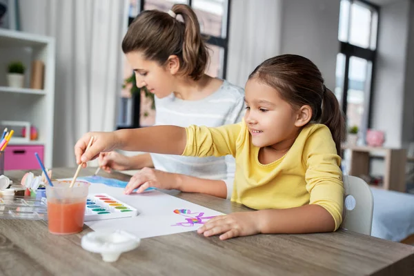 幼い娘が家で絵を描く母親は — ストック写真