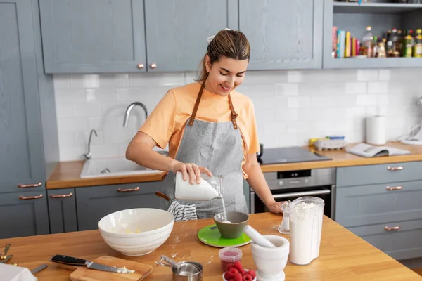 Mulher cozinhar alimentos e assar na cozinha em casa — Fotografia de Stock