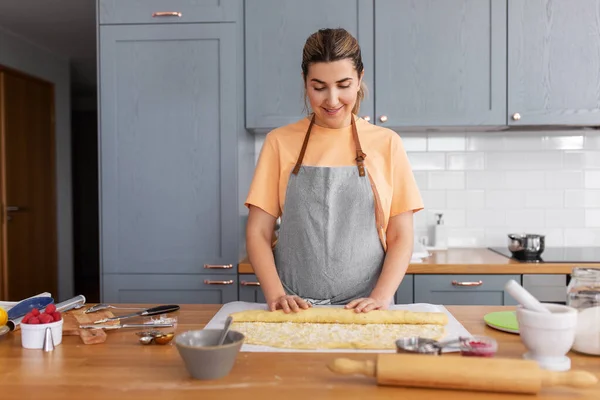 Женщина приготовление пищи и выпечка булочки на домашней кухне — стоковое фото